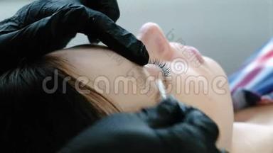 美容师用针头把睫毛分开。 肉毒杆菌和睫毛层压。 美容治疗。 特写眼睛。